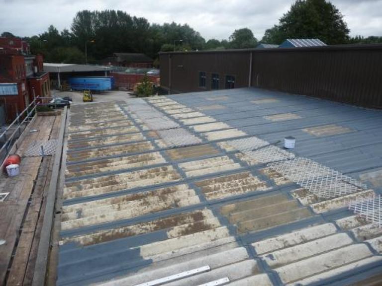 First coat of the liquid roofing system being applied to the flat roof